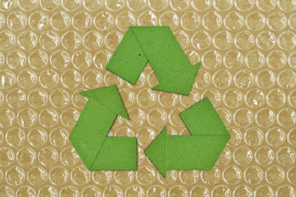 recycle sign on a backdrop of bubble wrap and cardboard